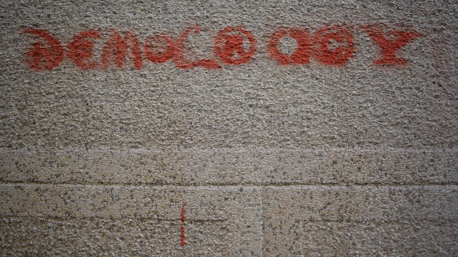 Schriftzug "Democracy" als Graffiti. Bild von Marija Zaric auf Unsplash.