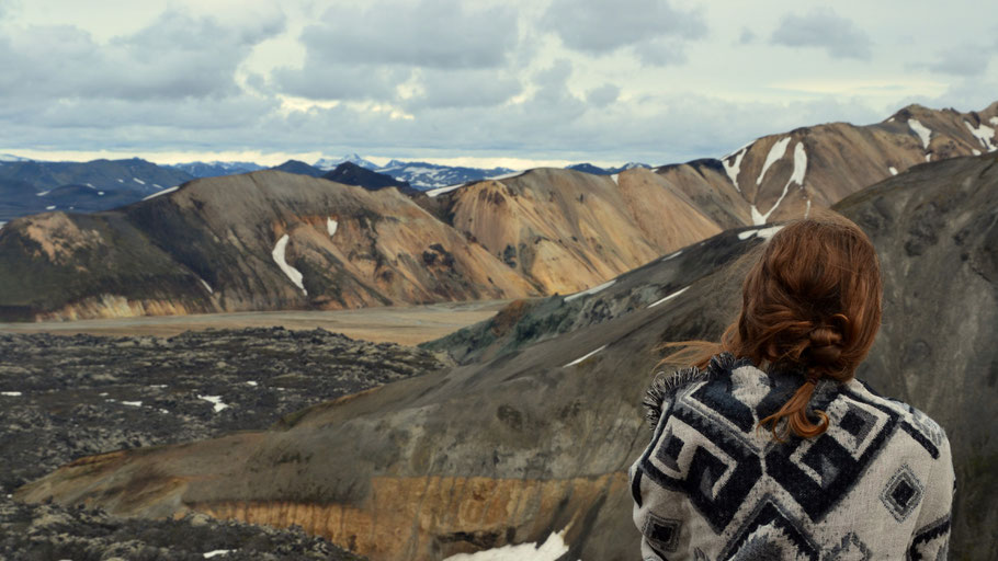 Eine Frau steht vor einer isländischen Gebirgskette. Bild von Agnieszka Bednarz auf Unsplash. 