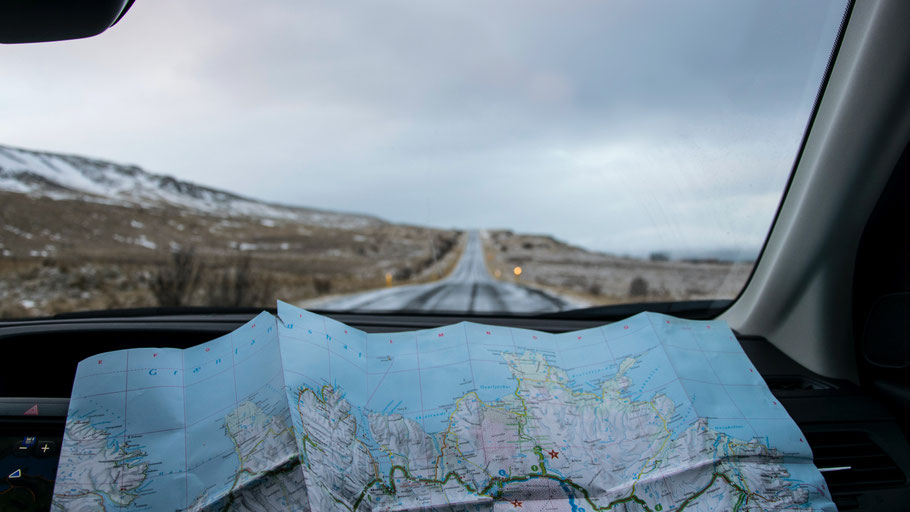 Karte von Island liegt in einem Auto. Bild von Tabea Damm auf Unsplash.