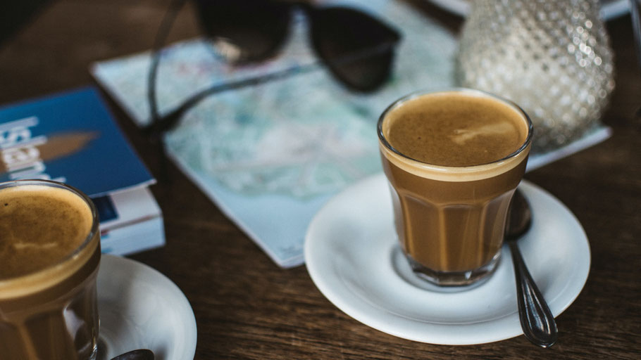 Zwei Kaffeetassen plus Island-Karte. Bild von Jakub Kapusnak auf Unsplash.