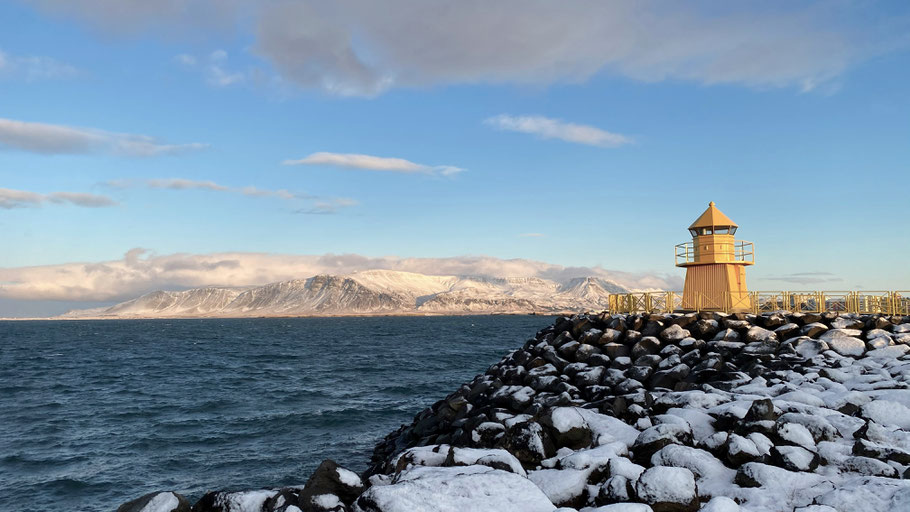 Gelber Leuchtturm an der isländischen Küste. Bild von Linmiao Xu auf Unsplash.