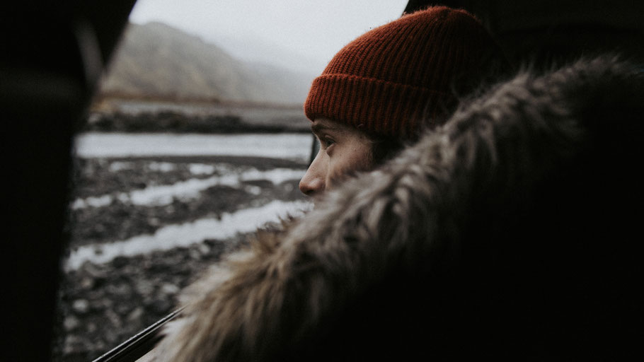 Frau sitzt am Autofenster und schaut auf die Landschaft. Bild von Becca Tapert auf Unsplash. 