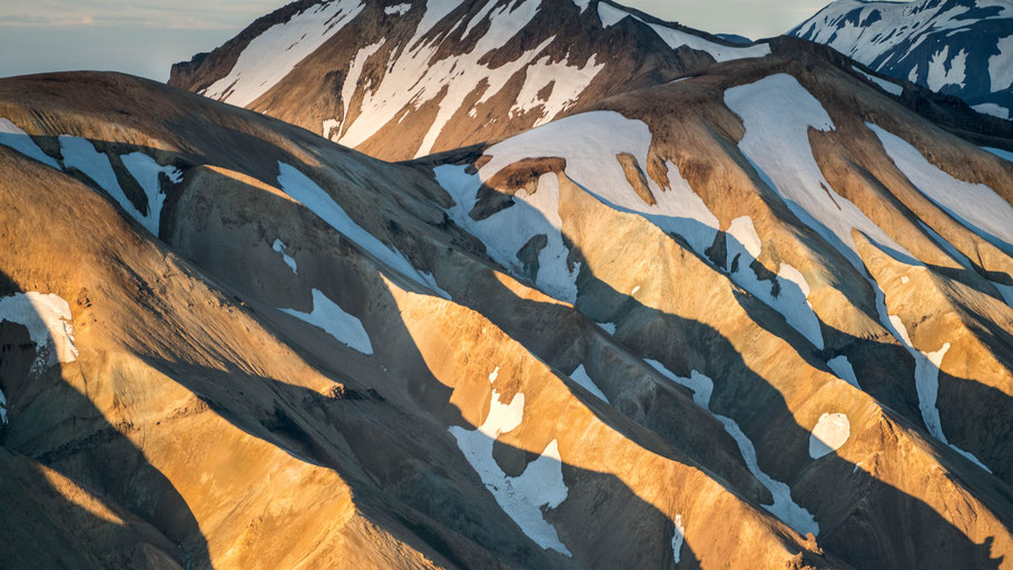 Schneebedeckte Bergkuppen in Island. Bild von Joshua Sortino auf Unsplash.