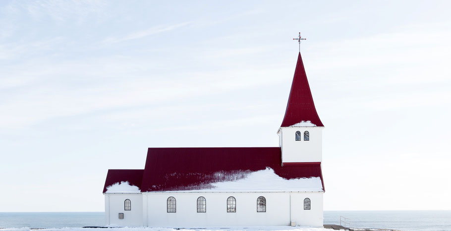 Weiße Kirche mit rotem Dach im Schnee. Bild von Jon Flobrant auf Unsplash.