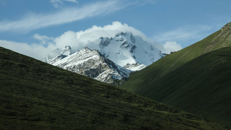 Grüne Berge vor schneebedeckter Kuppel. Bild von Jeremy Cai auf Unsplash.
