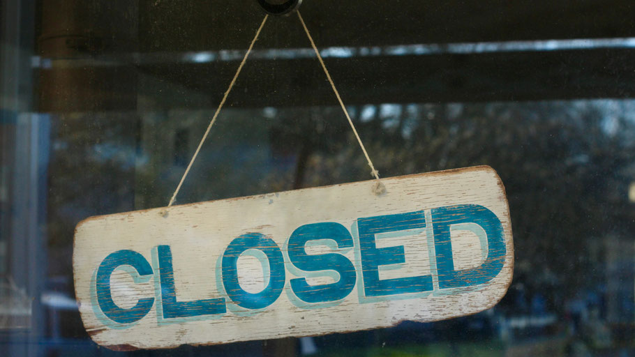 "Closed"-Schild in einem Schaufenster. Bild von Lisa Luminaire auf Unsplash.