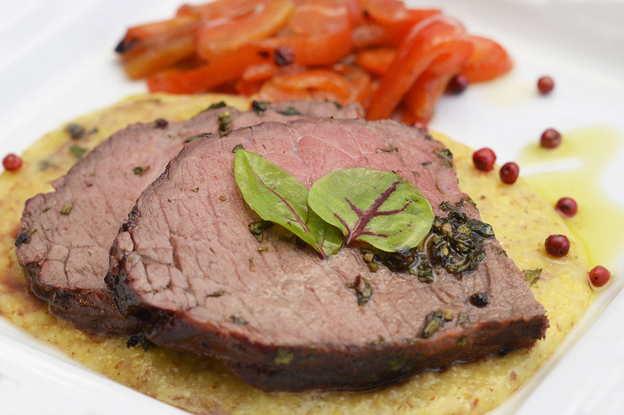 Roastbeef im Kräutermantel auf Traminer Plenten und marinierten Paprika.