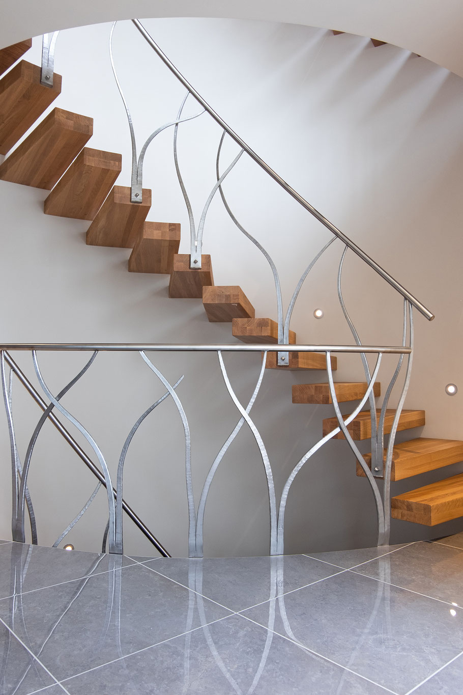 Gewendeltes Treppengeländer aus Edelstahl an einer freischwebenden Treppe