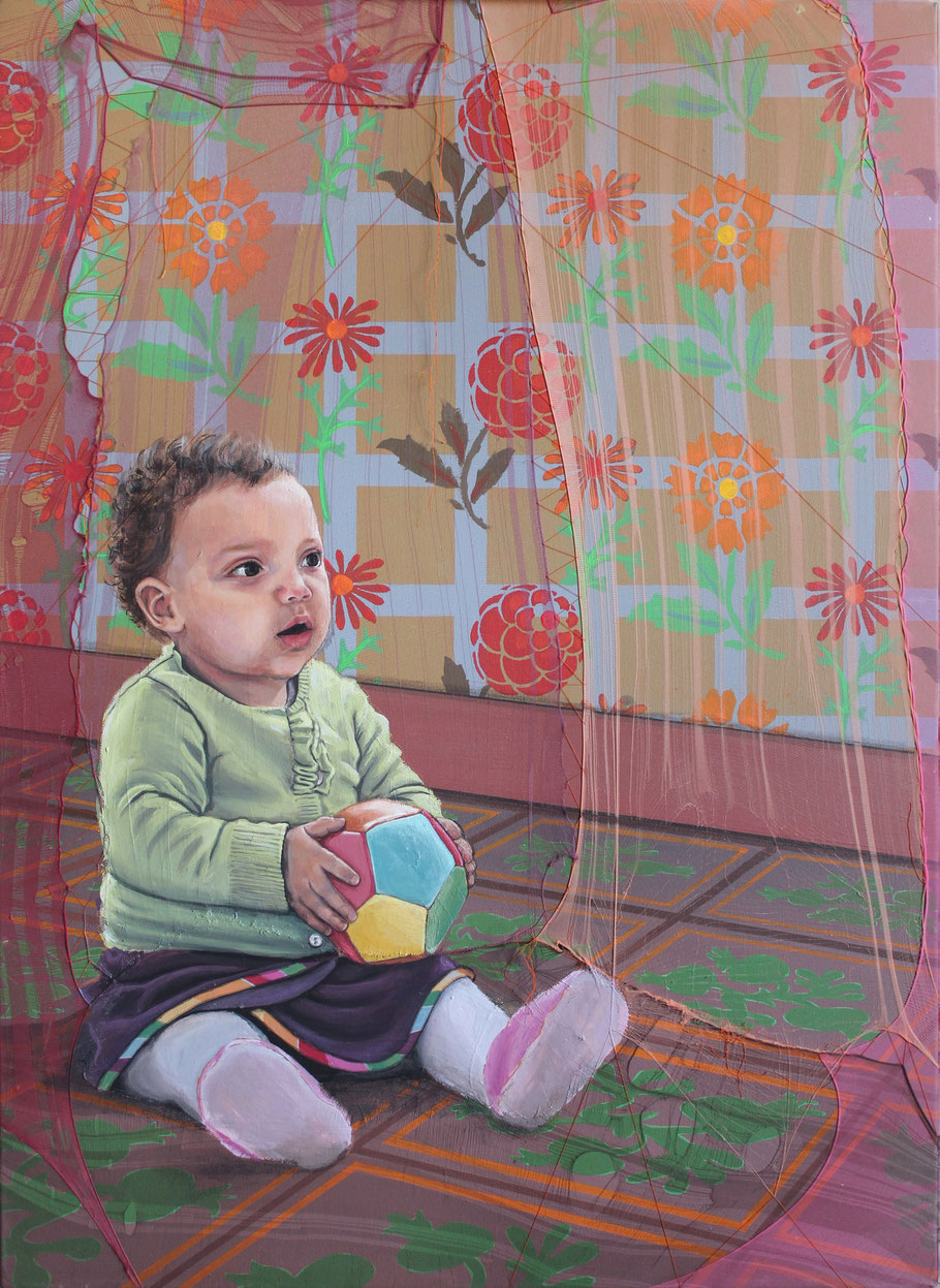 Portrait d’un bébé assis, tenant un ballon, sur un sol graphique devant un papier peint fleuri vintage. Settimia Taroux combine art textile, couture, peinture et motifs rétro pour évoquer l’innocence, la tendresse et la rudesse de la vie. 