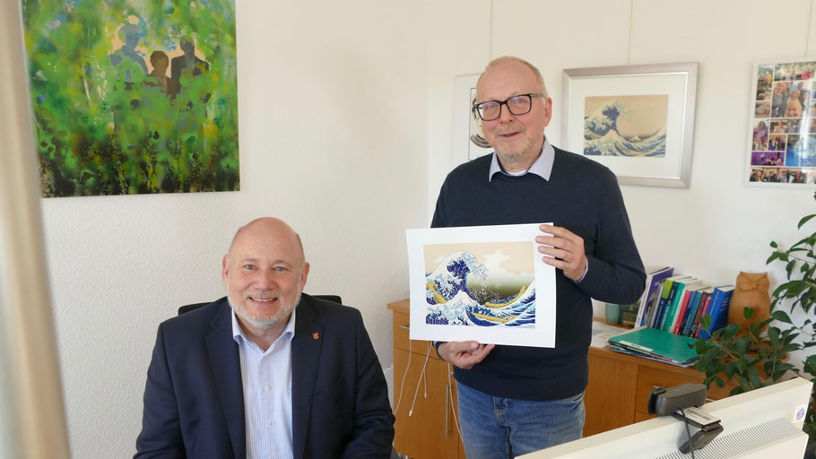 Als Gastgeschenk hatte Zaft eine eigener Version des Bildes „Große Welle" mitgebracht, das bereita im Büro hängt. Ob sich der Bürgermeister an seinem Arbeitsplatz durch „Die Geister" (Bild im Hintergrund) beobachtet fühlt, ist nicht bekannt .....