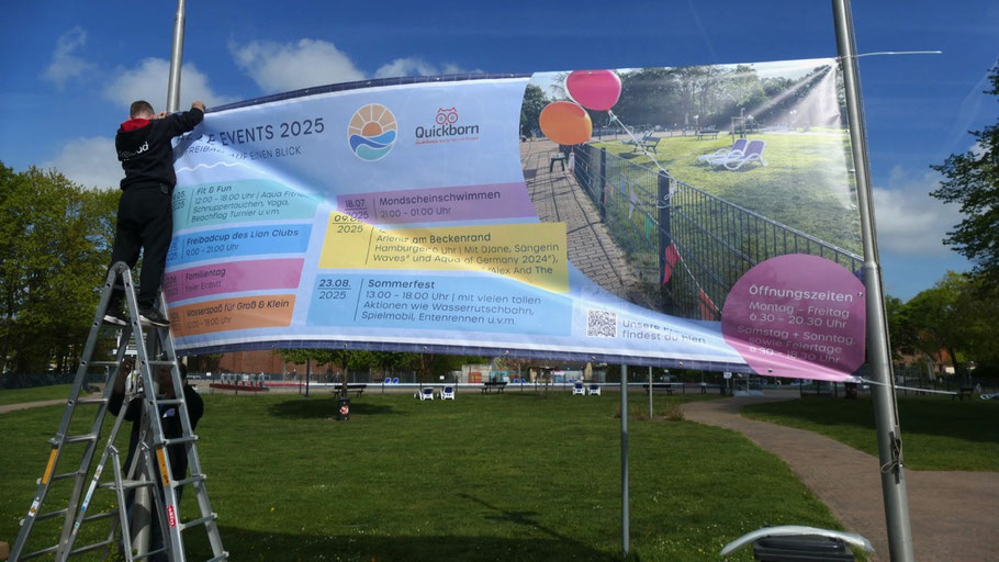 Ein großes Banner macht direkt am Eingang auf die zahlreichen Veranstaltungen im Freibad aufmerksam