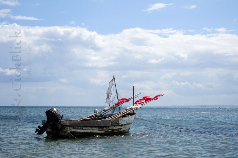 Fischerboot mit Reuse und Fahnen ankert in der Lübeckerbucht, Ostsee bei sonnigem Wetter  