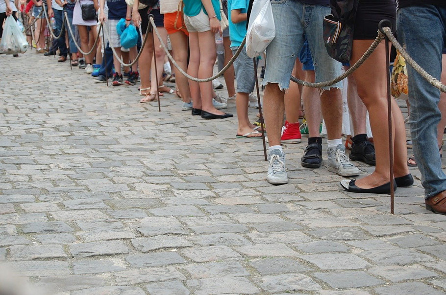 Photo of people queueing, which one can see only the legs