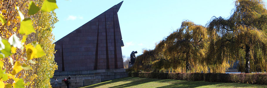 © Helga Karl. Sowjetisches Ehrenmal Treptower Park - Hängende Birken im Herbst, die Fahne aus Stein und Knieender Soldat