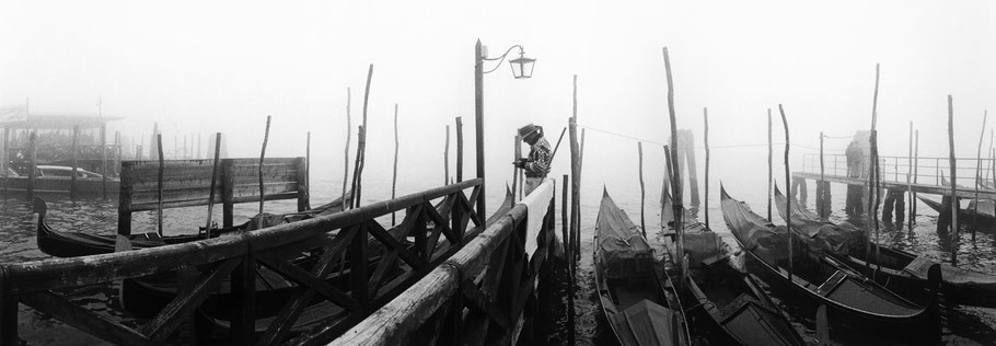 Nebelstimmung mit Gondoliere nähe Molo San Marco, Venedig, als Schwarzweißphoto im Panorama-Format