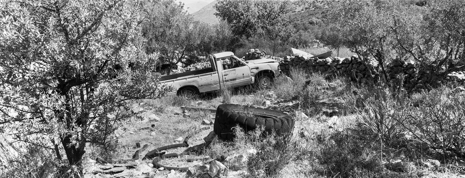 PKW Schrottwagen auf dem Peloponnes, Griechenland, als Schwarzweißphoto im Panorama-Format