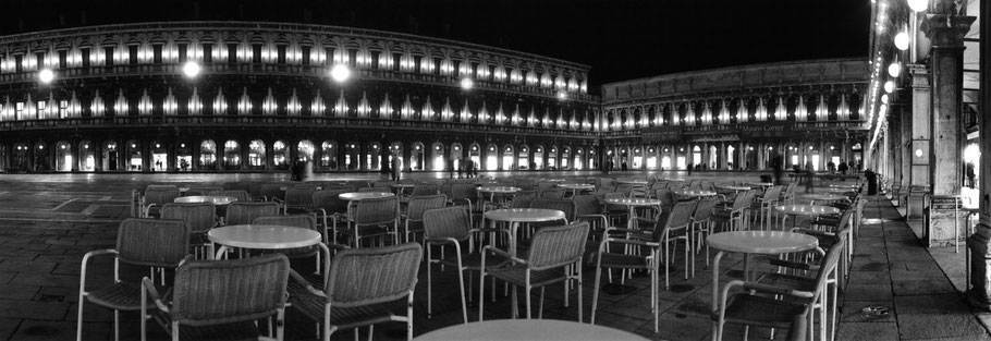 Nachtaufnahme des menschenleeren Piazza San Marco , Venedig, als Schwarzweißphoto im Panorama-Format