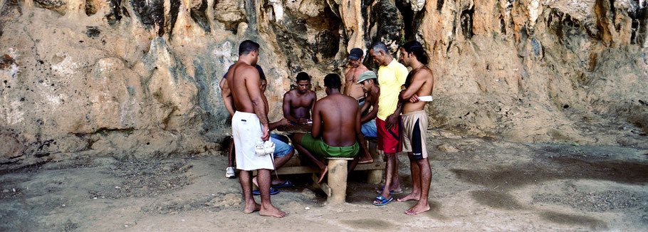 Acht Kubaner spielen in Maguana ein Brettspiel in der Natur, Farbphoto als Panorama-Photographie