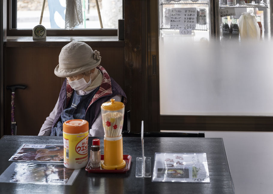 Alte Frau sitzt im Lokal als Farb-Photographie, Japan
