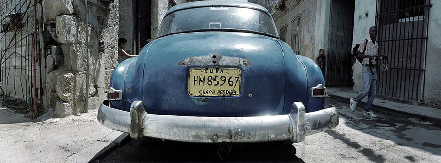 Blauer Oldtimer steht auf der Straße in der Altstadt von Havanna als Farbphoto im Panoramaformat, Cuba
