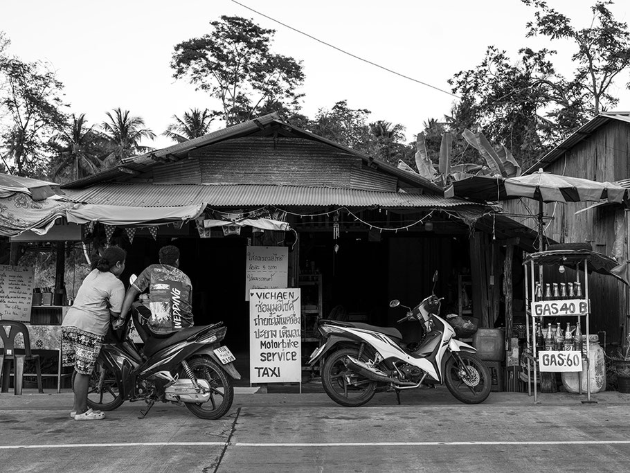 Verkauf von Benzin in herkömmlichen Getränkeflaschen am Straßenrand in Thailand als SW-Fotografie