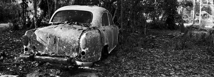 Reste von Oldtimer-Taxi bei Marari in Kerala , Indien, als Schwarzweißphoto im Panorama-Format