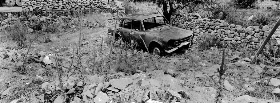 Alter Fiat in Areopoli auf dem Peloponnes, Griechenland,  als Schwarzweißphoto im Panorama-Format