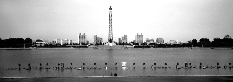 Blick über den Taedong River  auf den Juche Turm in Pyongyang, Nord Korea, als Schwarzweißphoto im Panorama-Format