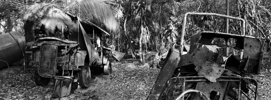 Reste von Oldtimern bei Marari in Kerala , Indien, als Schwarzweißphoto im Panorama-Format