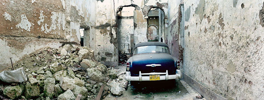 Oldtimer im Hinterhof in der Altstadt von Havanna als Farbphoto im Panoramaformat, Cuba