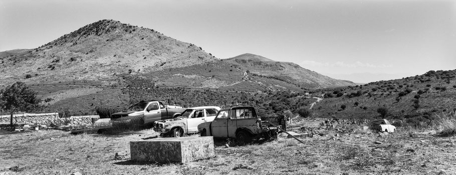 PKW Schrottwagen auf dem Peloponnes, Griechenland, als Schwarzweißphoto im Panorama-Format