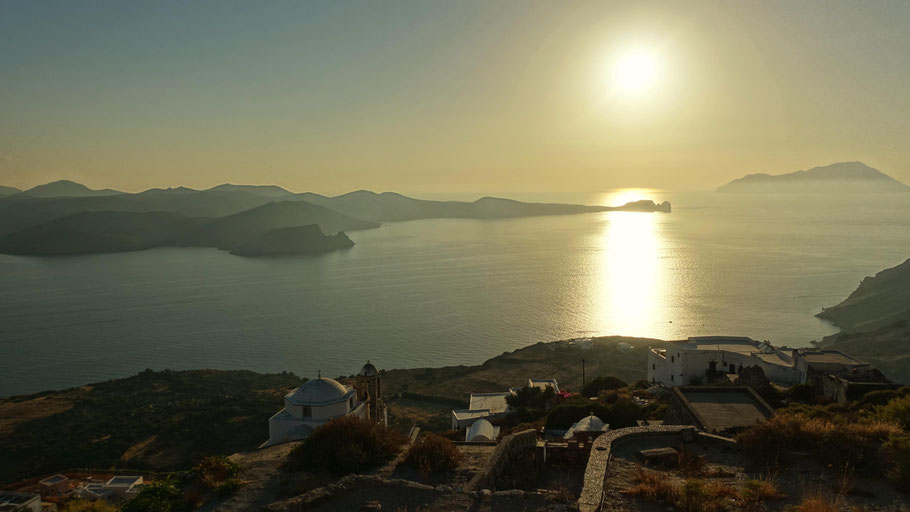 Grèce, Cyclades : coucher de soleil sur la baie de Milos en montant vers le kastro de Plaka