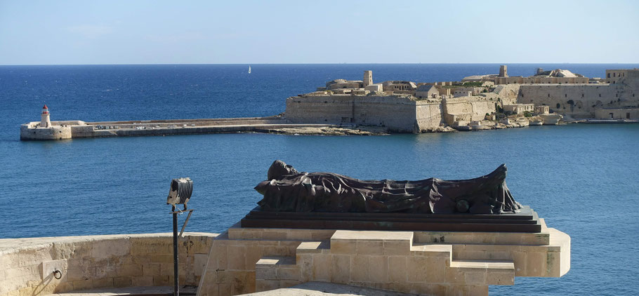 Malte, La Valette : vue des Lower Barrakka Gardens sur le fort et le phare de Ricasoli avec au premier plan la statue du Soldat Tombé
