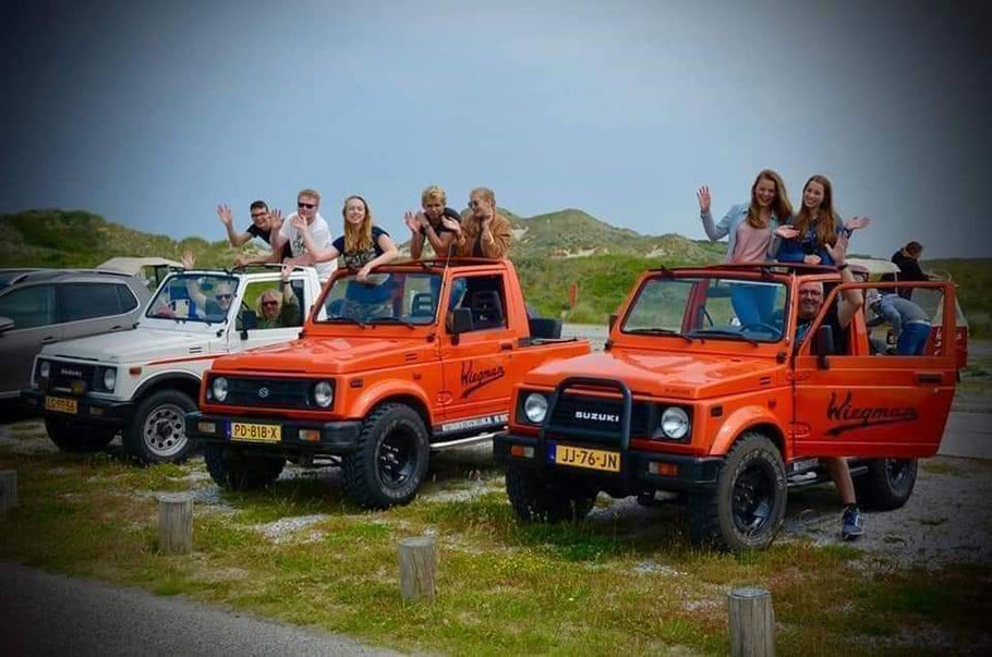 Drive Suzuki Samurai's geparkeerd bij het strandpaviloen met mensen die de auto's hebben gehuurd.