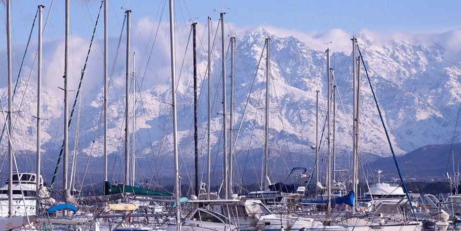 Vue du port de Calvi l'hiver avec les plus hauts sommets enneigés de la Corse