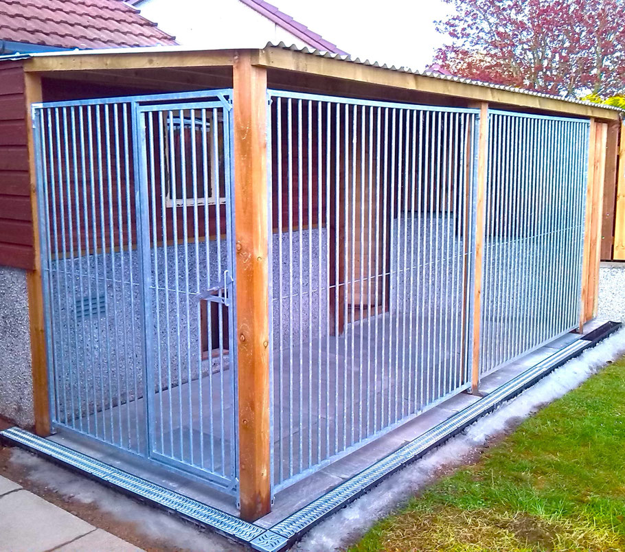 Brick and wood shed with attached dog kennel run, concrete slab flooring, and corrugated roof.