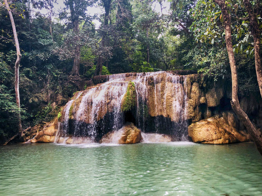 Die Felsen, Pools und Fische des Erawan Wasserfalls verwandeln die Landschaft zu einem spaßigen Wasserpark.