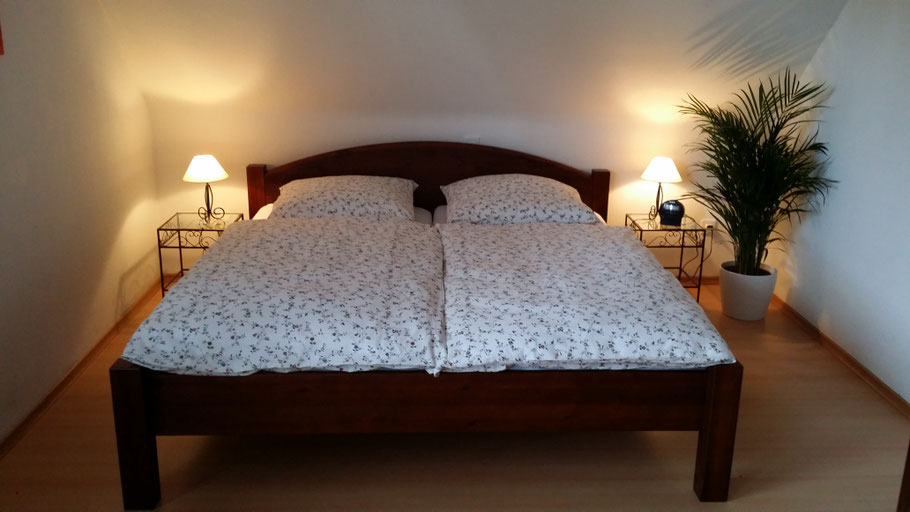 Schlafzimmer mit Doppelbett, Sessel und Kleiderschrank
