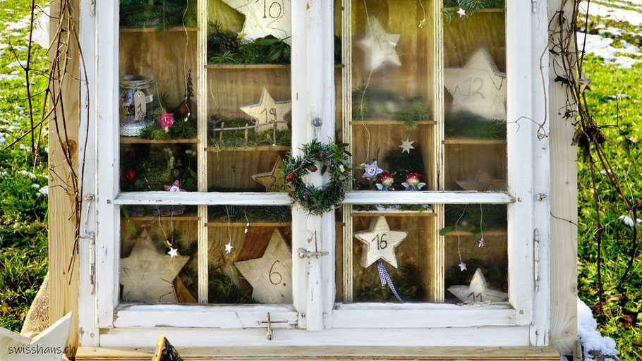 Weihnachtlich geschmücktes Fenster mit Adventskalender-Sternen