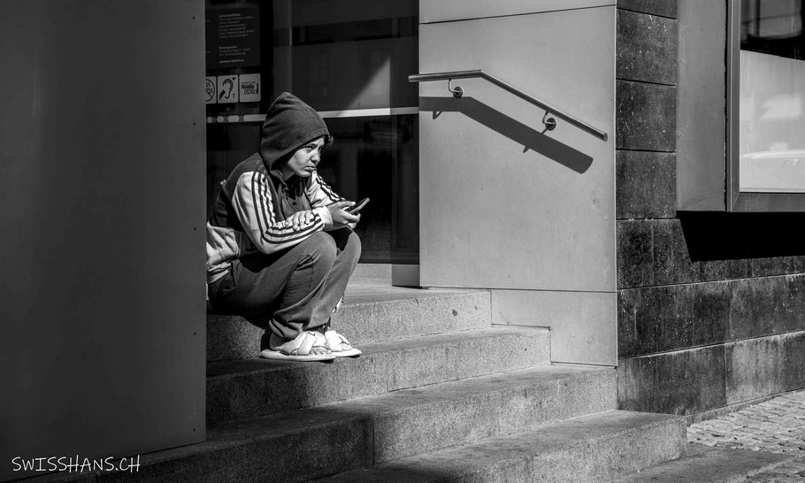 Eine Frau sitzt auf der Treppe und macht sich Gedanken.