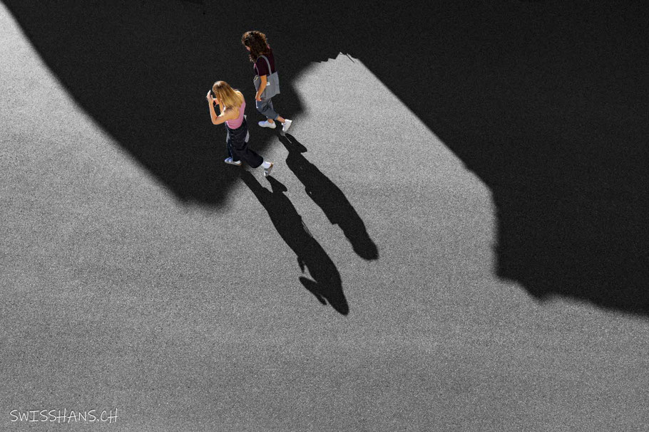 Zwei Damen gehen auf der Strasse mit Schatten