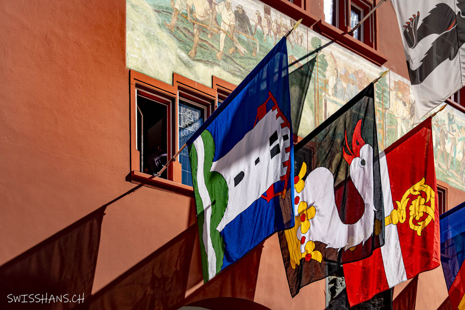 Fassade des Rathauses Appenzell mit bunten Fahnen, bunten Fensterscheiben und einer einzigartigen Fassadenmalerei