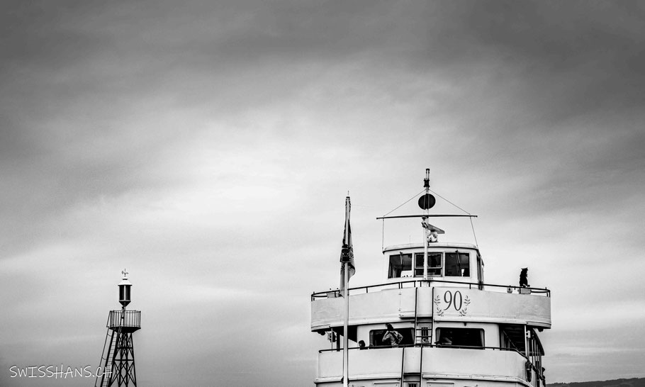Ein Schiff fährt am Leuchtturm vorbei in den Hafen von Rorschach.