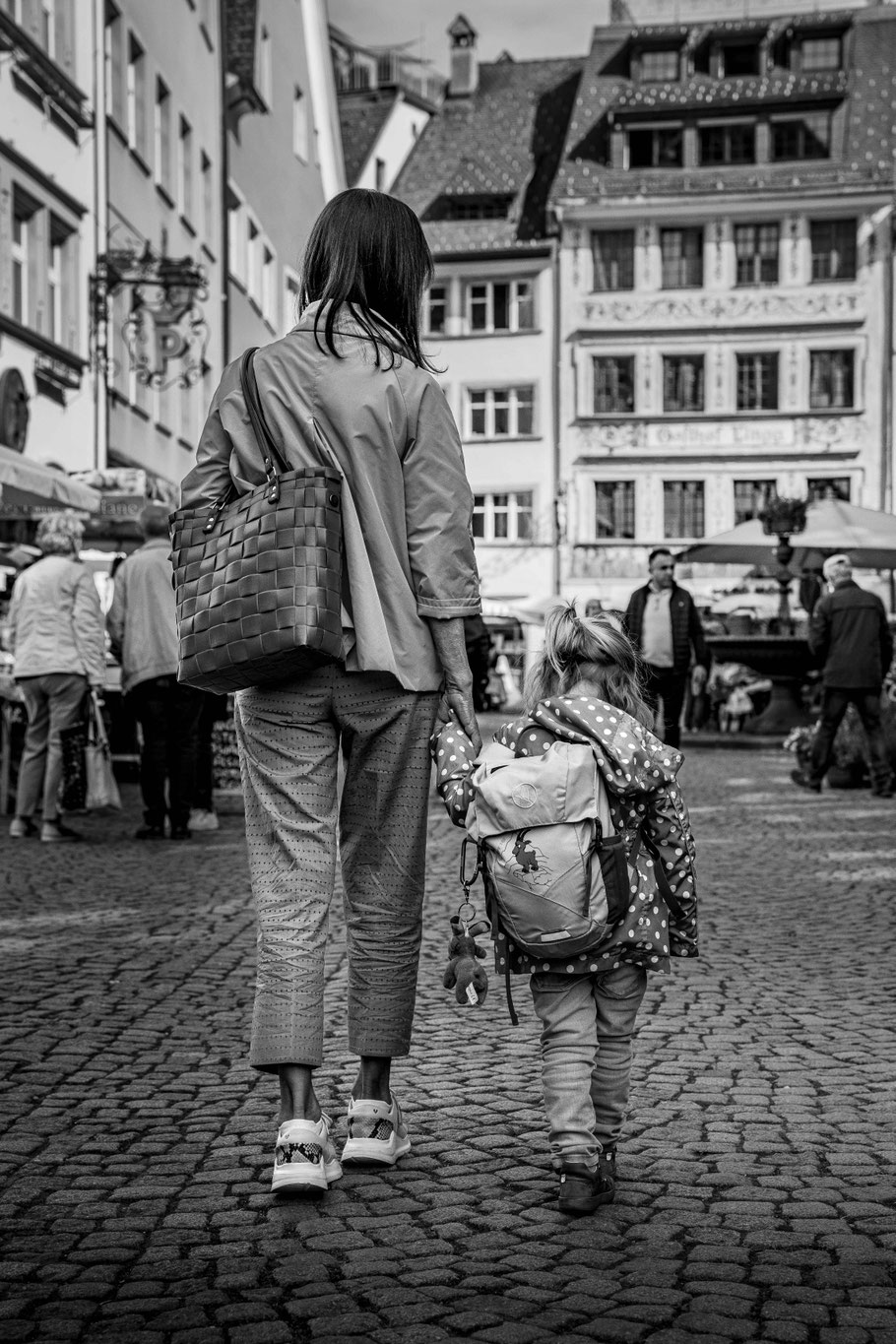 Ein Mädchen spaziert mit der Oma durch den Wochenmarkt