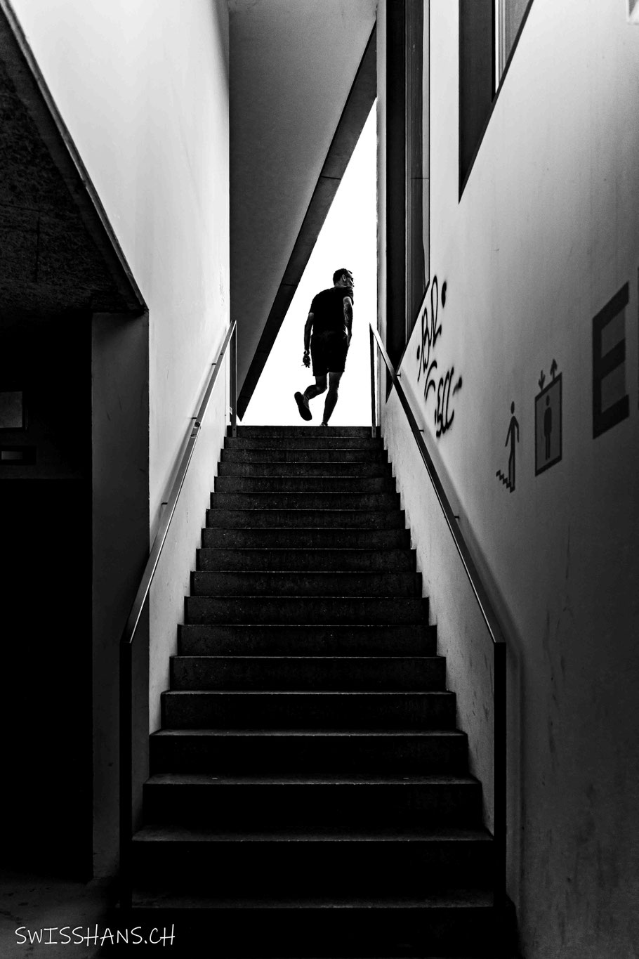 Ein Mann verlässt die Tiefgarage über eine Treppe.