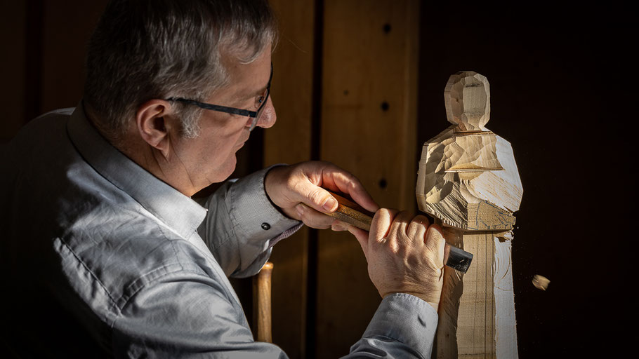 Robert-Hangartner-Holzbildhauermeister-Altstätten-beim-Schnitzen-in-der-Werkstatt-mit-Holzspan