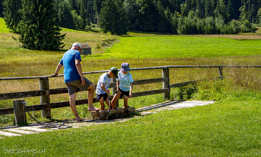 Wassertrog mit Wasserschlauch um sich die Füsse auf dem Barfussweg abzuwaschen