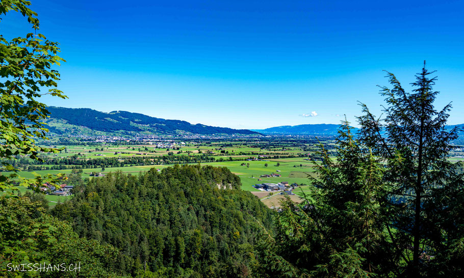 Aussicht auf das Rheintal mit Bäumen, Wald und blauem Himmel von der Plattform der Kristallhöhle Kobelwald