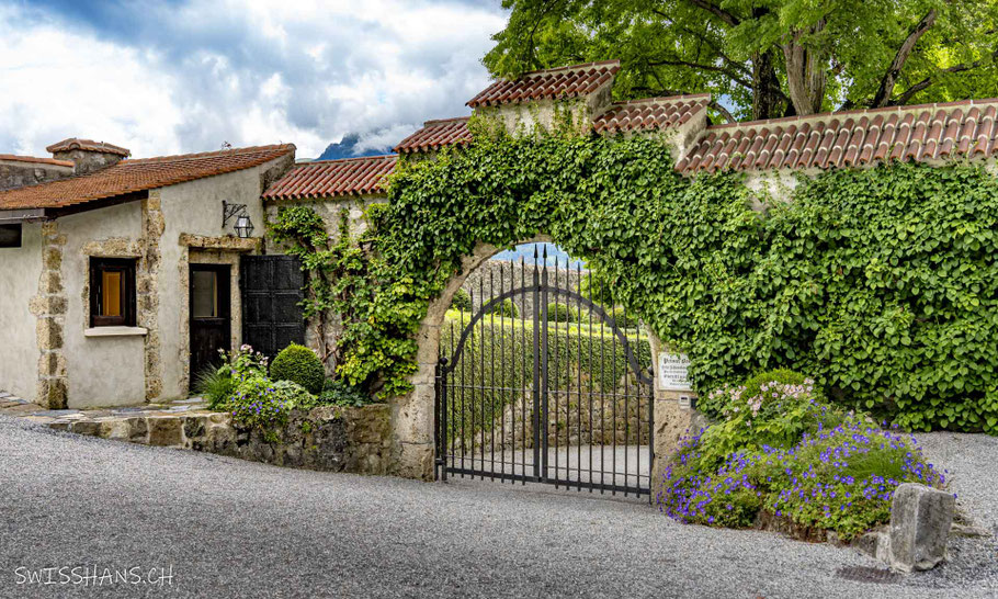 Schmiedeeisentor und Wächterhaus des Schlosses Vaduz mit Blumenschmuck