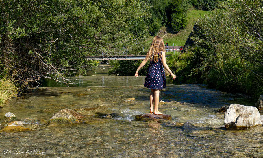 Mädchen steht auf einem Stein im Bachbett beim Barfussweg Jakobsbad-Gontenbad